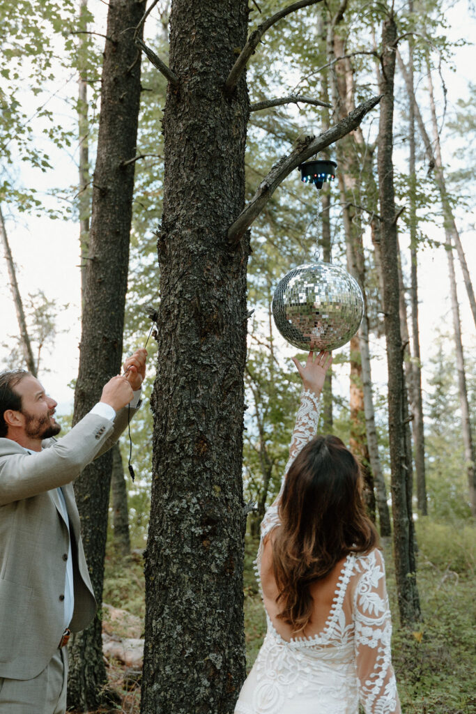 Newlyweds hang a disco ball in the forest for their first dance