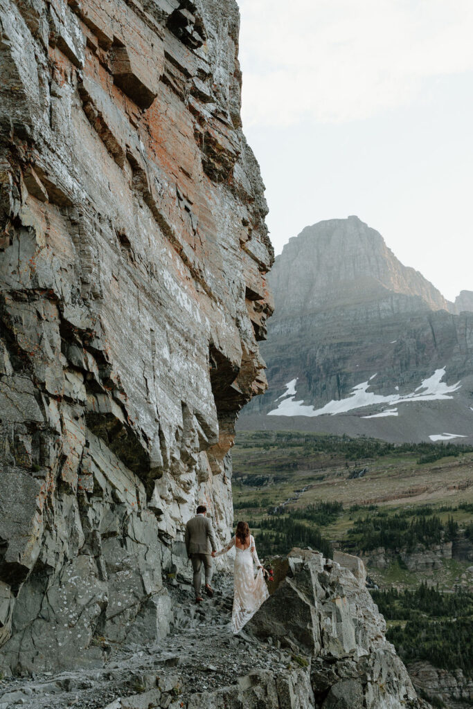 Newlyweds head out on the Highline Trail hike during their elopement in Glacier National Park
