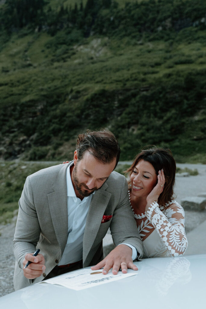 Newlyweds sign their marriage license during their Glacier National Park elopement