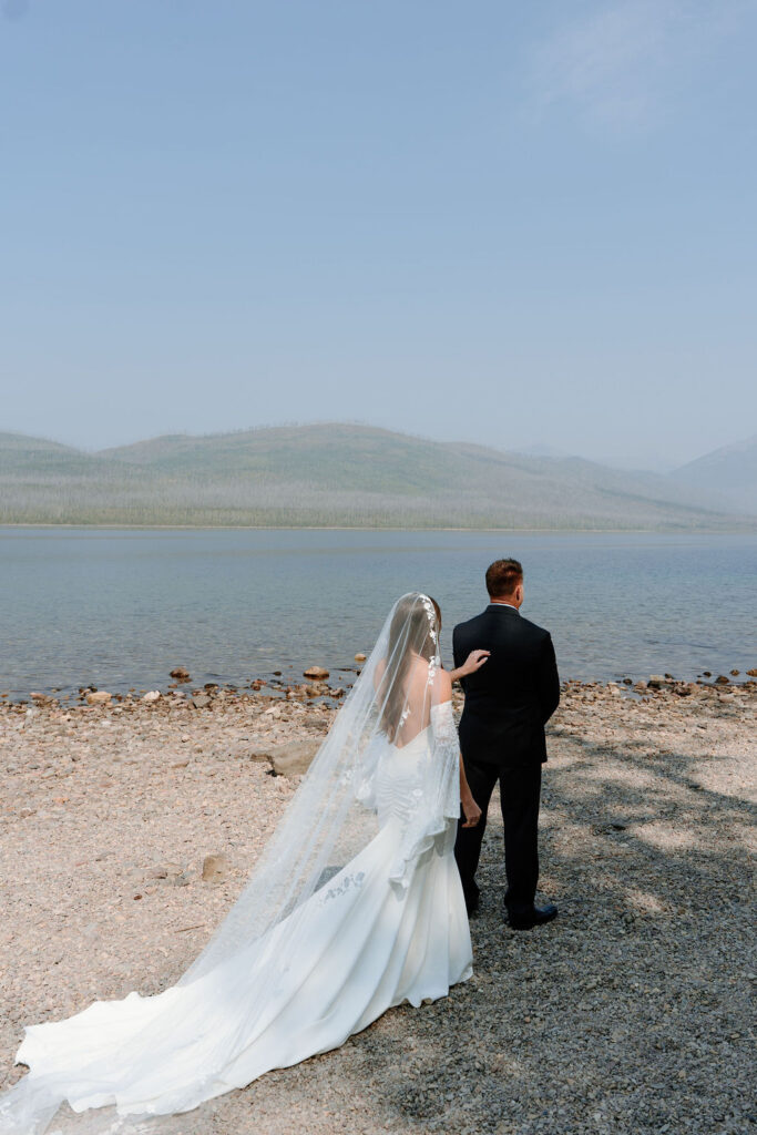 A bride shares a first look with her father at Avalanche Lake before her wedding ceremony begins