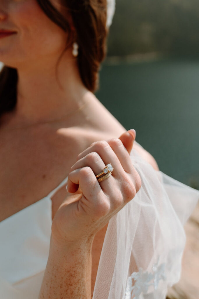 A bride shows off her new wedding band during bridal portraits at Sun Point