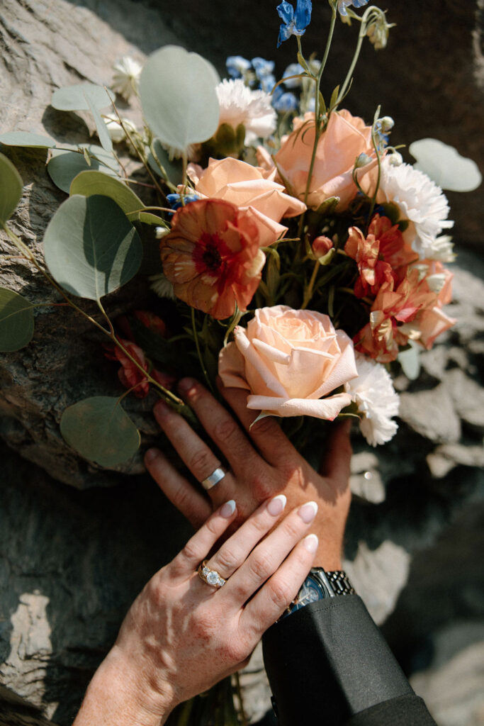 Bride and groom show off their wedding bands during their Glacier National Park elopement